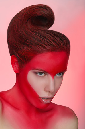 Portrait of woman with face art in form of red heartの写真素材