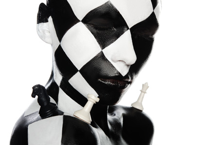 of a young woman with chess visage and piecesの写真素材