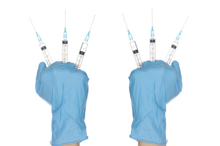Gloved hands holding six syringes isolated on whiteの写真素材