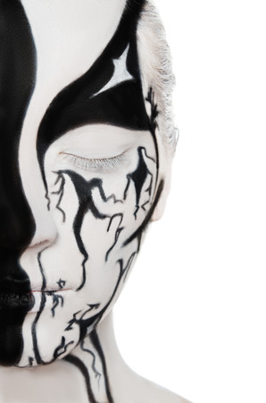 Portrait of young woman with black and white colors on face isolated on whiteの写真素材