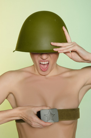 Young woman screaming in army helmet and shoulder strapの写真素材