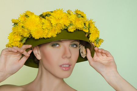Woman in  helmet with a wreath of yellow dandelionsの写真素材