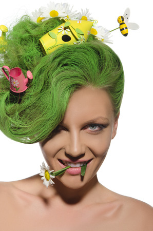 Woman with green hair in disorder and chamomile in mouthの写真素材