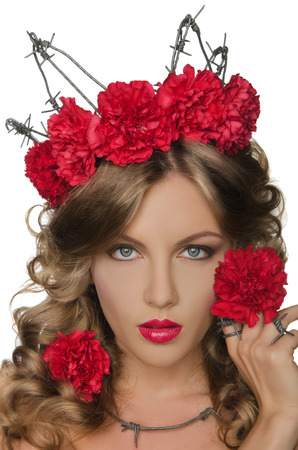 Beautiful young woman wearing crown of barbed wire with carnationsの写真素材