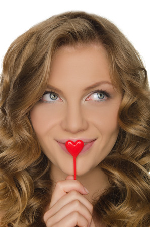 Beautiful young woman holding heart in front lipの写真素材