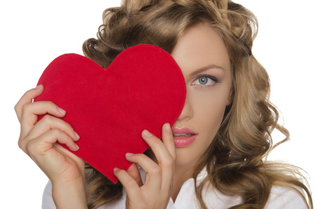 Beautiful young woman holding heart in front of eyeの写真素材