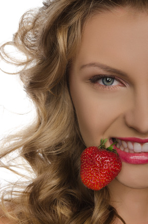 Young woman with strawberry teeth isolated on whiteの写真素材
