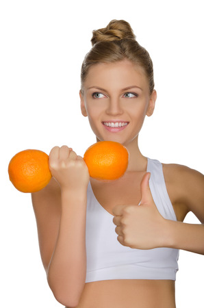 happy woman with dumbbells fruits looking away isolated on whiteの写真素材