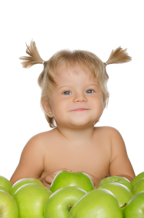 Little happy girl with green apples isolated on whiteの写真素材