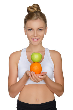 Beautiful woman with apple and orange isolated on whiteの写真素材