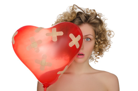 Balloon in shape of heart and upset woman isolated on whiteの写真素材