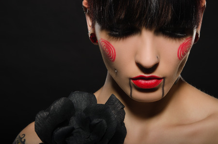 tattooed beautiful brunette with black flower on dark backgroundの写真素材