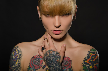 Beautiful blonde with a tattoo on body, dark backgroundの写真素材