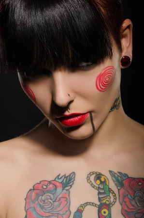 Charming brunette with a tattoo on body, dark backgroundの写真素材