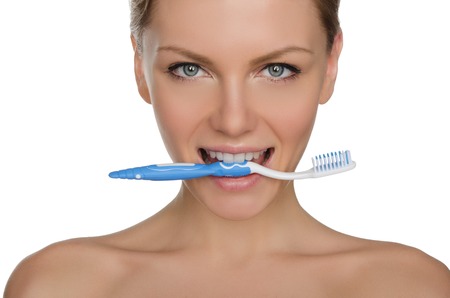 Portrait of happy woman with toothbrush in his teeth isolated on whiteの写真素材