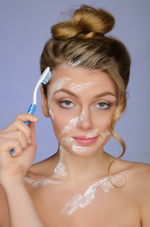 Surprised woman with toothbrush and toothpaste on a blue backgroundの写真素材