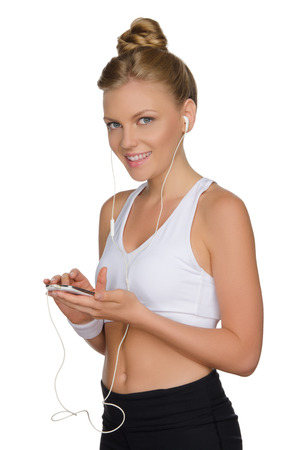 charming athletic woman with headphone and phone isolated on whiteの写真素材
