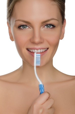 smiling woman with toothbrush in mouth isolated on whiteの写真素材