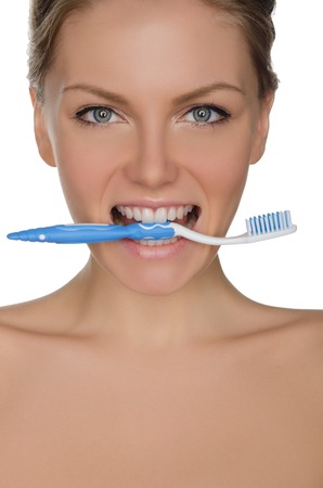 Portrait of beautiful woman with toothbrush in his teeth isolated on whiteの写真素材