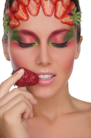 smiling woman with strawberries on face and hand isolated on whiteの写真素材