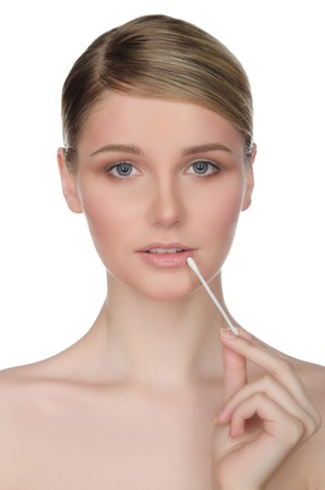 woman holding cotton swabs at mouth isolated on whiteの写真素材