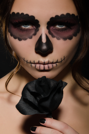 portrait of young woman with face art and flower studio shotの写真素材