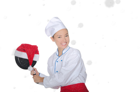 fun asian chef with frying pan and Christmas hat in falling snowの写真素材
