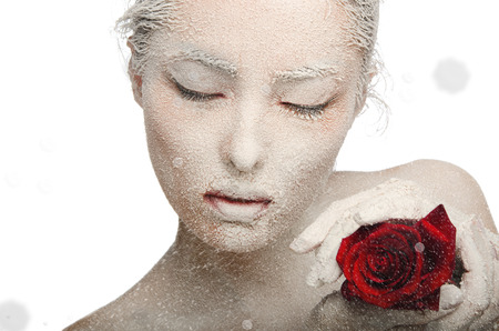 Frozen woman in snow and with rose in his hands Isolated on whiteの写真素材