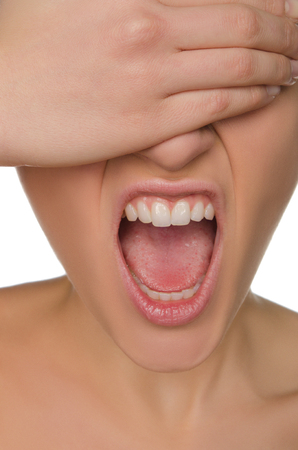wailing woman shields her eyes from hand shot in studioの写真素材