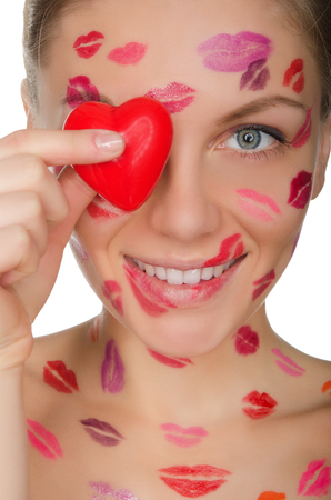 beautiful woman with kisses on face holding heart eyes isolated on whiteの写真素材