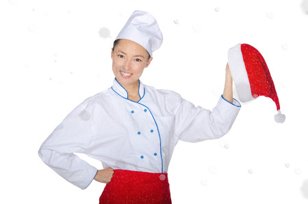 Happy asian chef with christmas cap in snow isolated on whiteの写真素材
