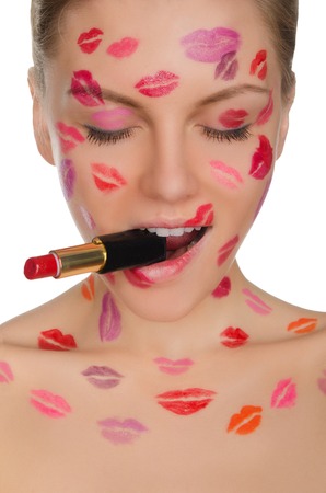 woman with kisses on face and lipstick in mouth isolated on whiteの写真素材