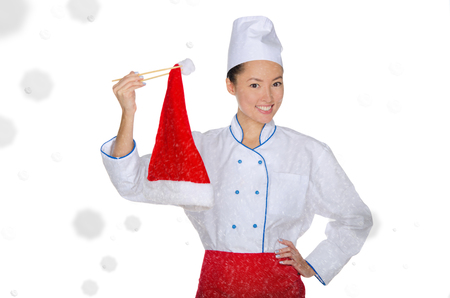 happy asian chef in christmas cap with chopsticks under snow isolated on whiteの写真素材