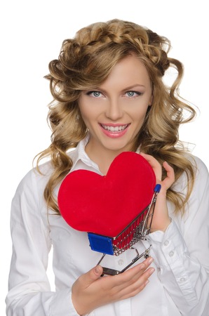 smiling woman with heart in shopping cart isolated on whiteの写真素材