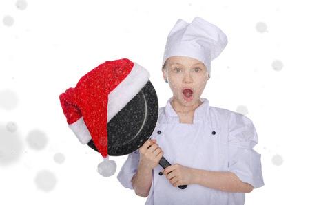 Surprised girl with frying pan and Santa hat on white background with snowの写真素材