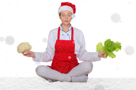 cook in Santa hat, yoga, vegetables under snow on white backgroundの写真素材