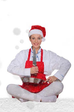 Woman cook in Santa Claus hat, yoga, knife under snow on white backgroundの写真素材
