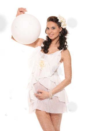 Pregnant woman with ball in snow isolated on whiteの写真素材