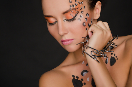 beautiful woman with animal face art and spines on dark backgroundの写真素材