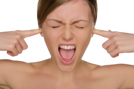 Beautiful emotional woman covers her ears with fingers isolated on whiteの写真素材