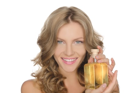 Beautiful woman with moisturizing skin oil isolated on whiteの写真素材
