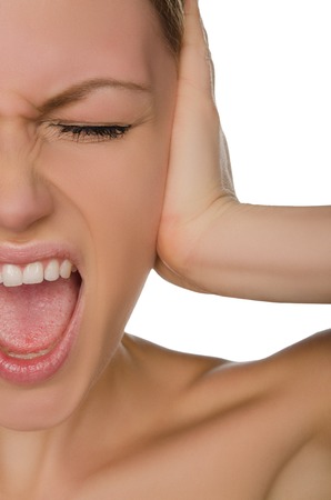 Emotional beautiful woman covers her ear with her palm isolated on whiteの写真素材