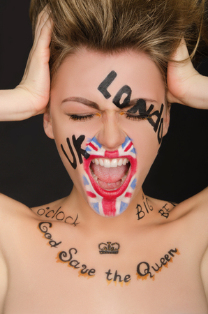 Emotional young woman with english face art, black backgroundの写真素材