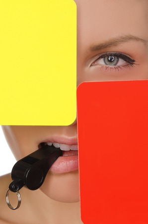 beautiful woman, red and yellow soccer referee and whistle isolated on whiteの写真素材