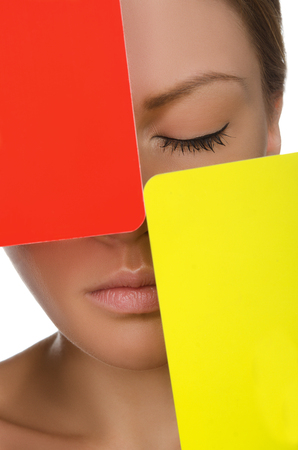 European beautiful woman with red and yellow card isolated on whiteの写真素材