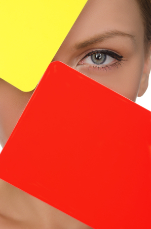 face of beautiful woman with red and yellow soccer card isolated on whiteの写真素材