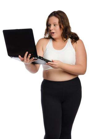 surprised fat sporty woman with laptop isolated on whiteの写真素材