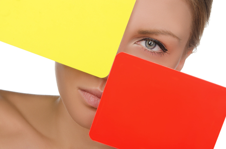woman with red and yellow soccer card isolated on whiteの写真素材