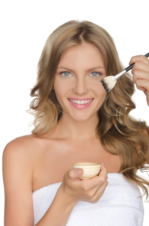 European woman moisturizing her skin with oil, white backgroundの写真素材