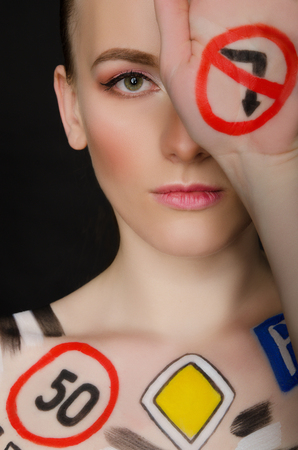 woman with painted road signs, dark backgroundの写真素材